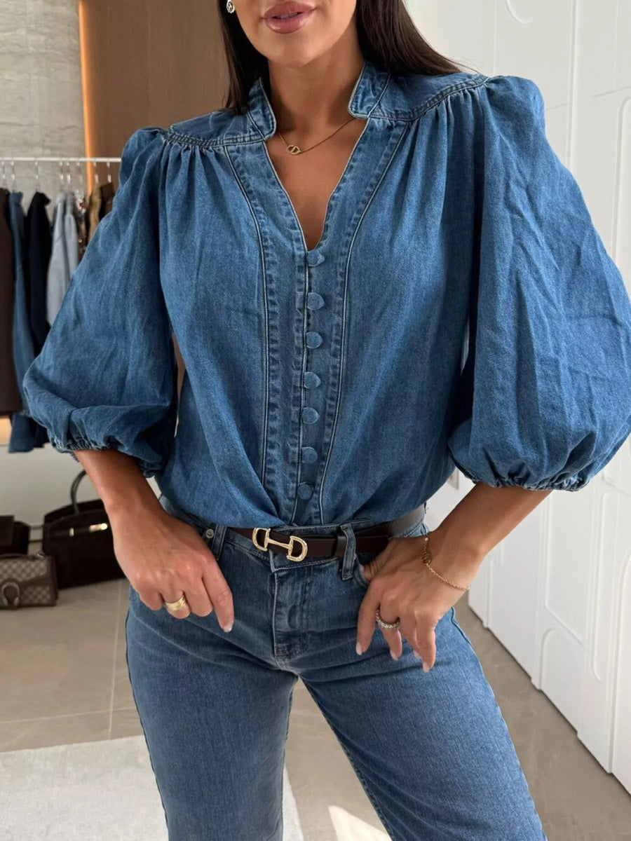 Denim button-down blouse with puff sleeves and a V-neckline in dark blue.