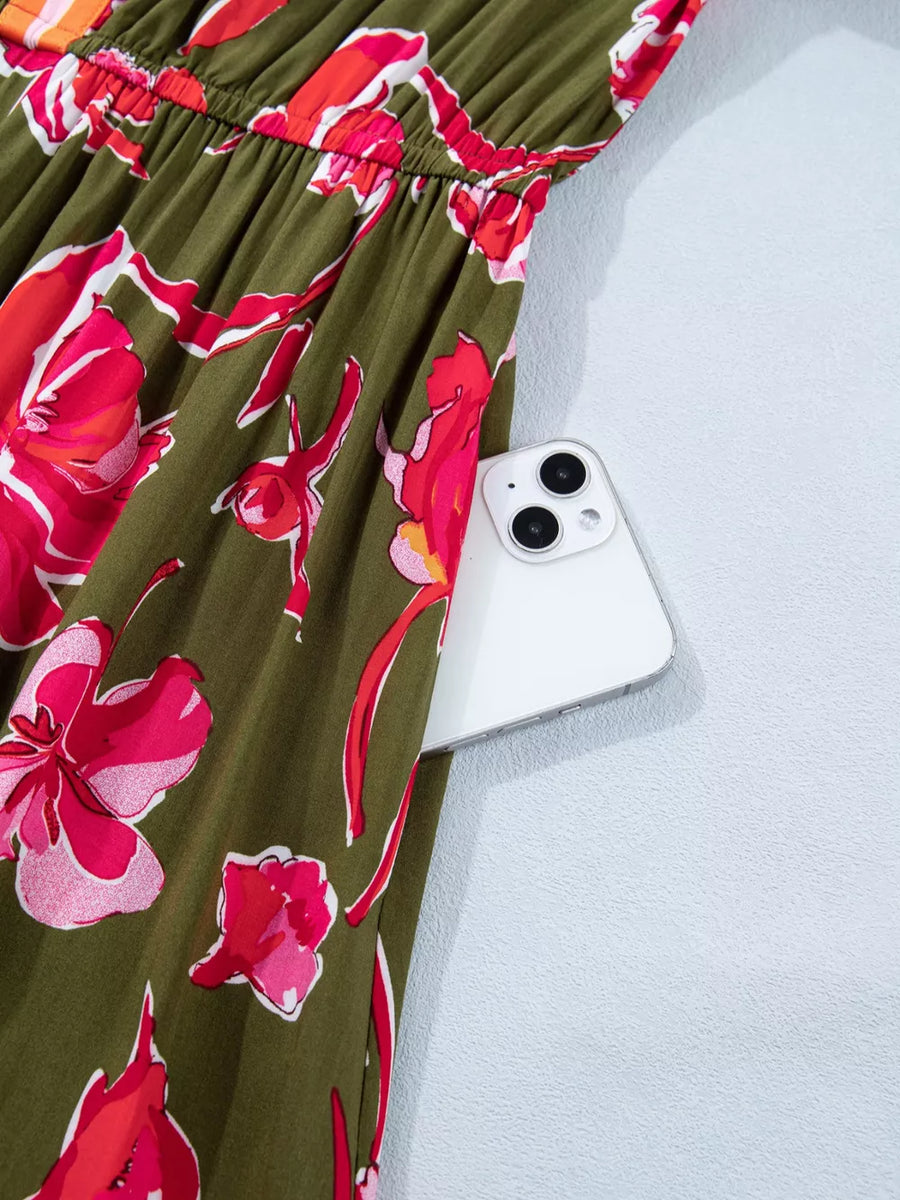 Print split neck dress in olive green with pink floral pattern and side pocket holding a phone.