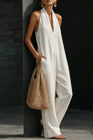 White halter neck pocketed jumpsuit with wide legs and a deep V-neck.