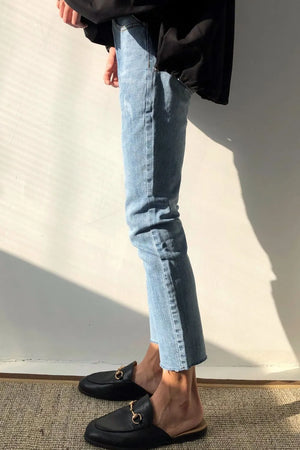 Medium wash slim-fit jeans with raw hem detail