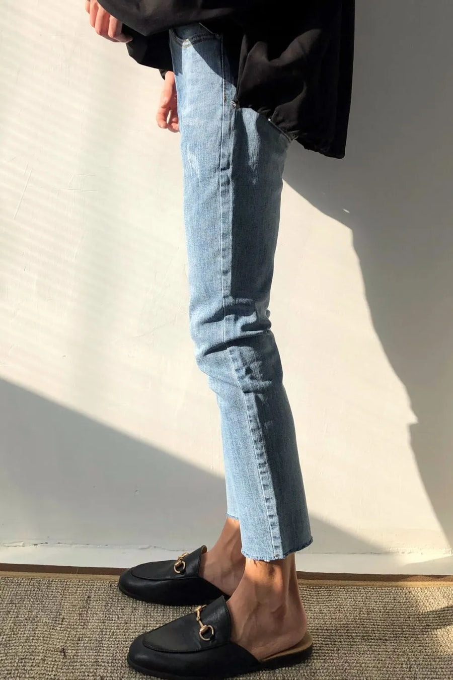Medium wash slim-fit jeans with raw hem detail