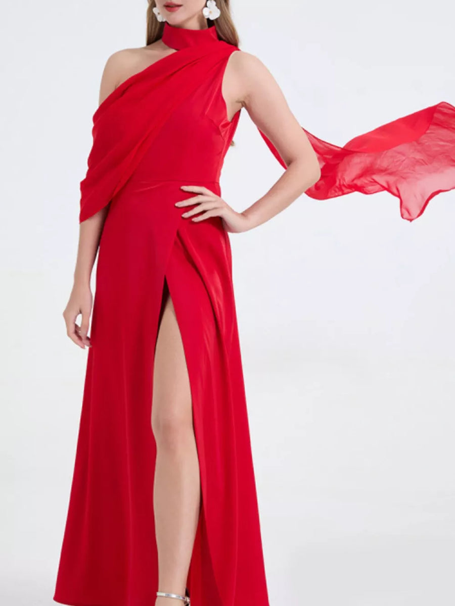 Red asymmetrical maxi dress with high slit and draped detail.