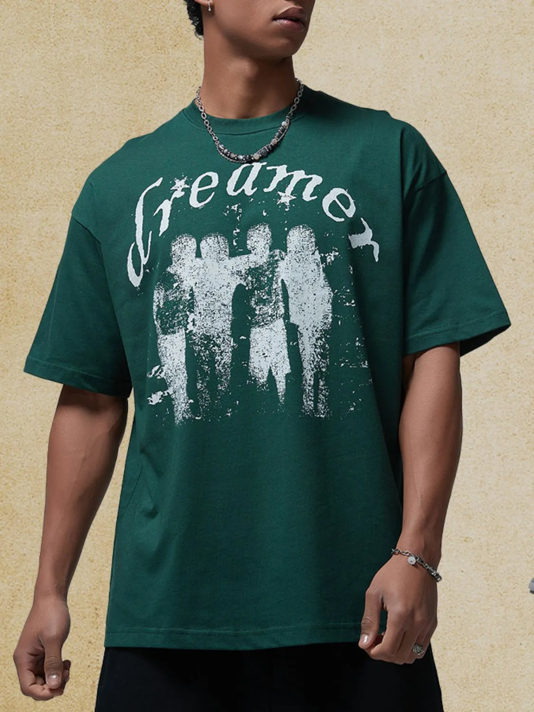 Dark green oversized graphic tee with white "Dreamer" text and distressed figures.