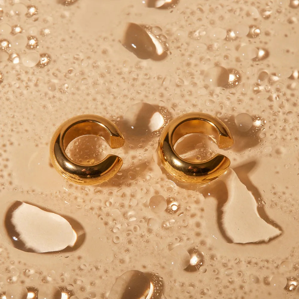 Sculptural gold-tone ear cuff duo with contemporary design and clip-on style.