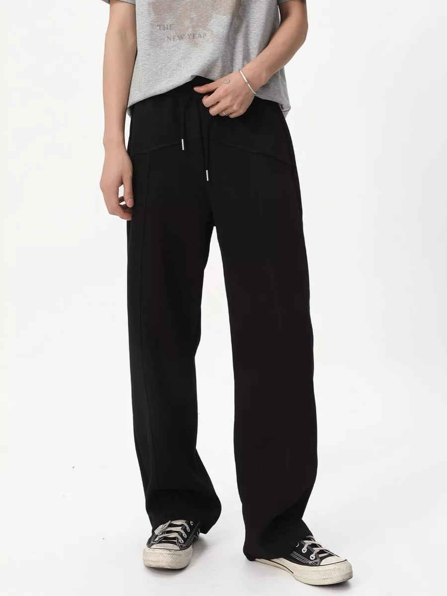 Black cotton wide-leg drawstring sweatpants with a tailored look and visible stitching.