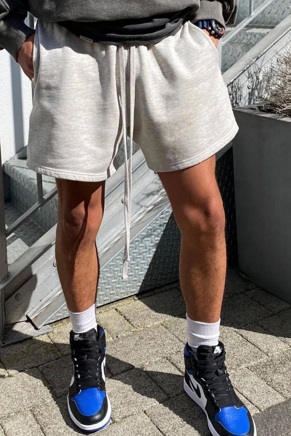 Light gray fleece drawstring jogger shorts with pockets and a relaxed fit.