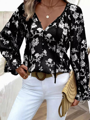 Black embroidered sheer long-sleeve blouse with tie neck and pearl buttons.