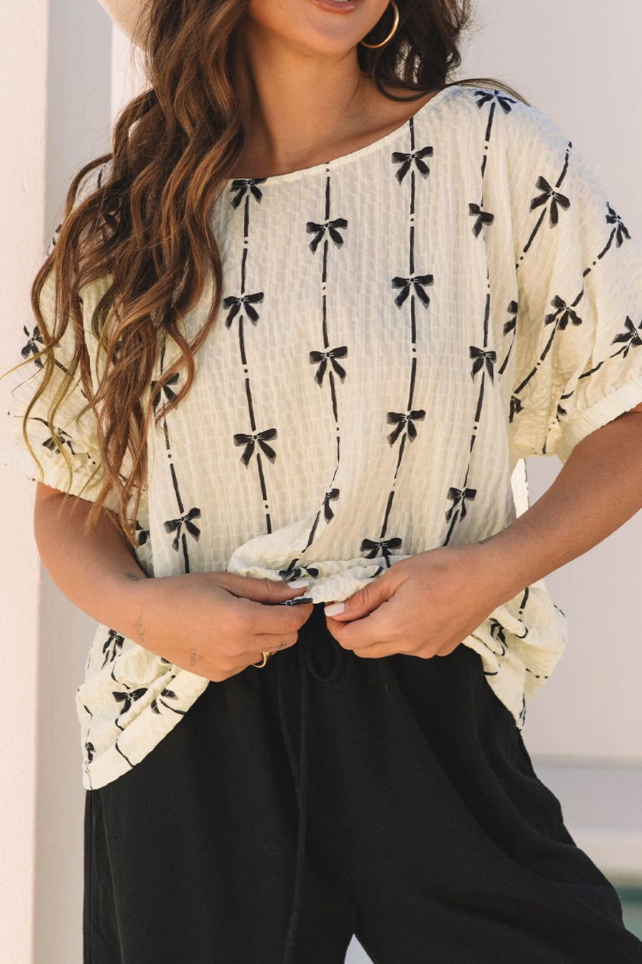 Beige gauze blouse with black bow print and gathered sleeves.