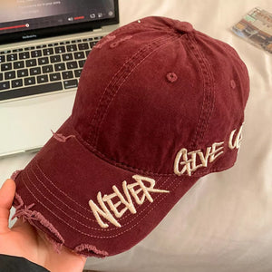 Wine red distressed denim baseball cap with embroidered "NEVER GIVE U" text.