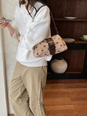 Gray shoulder bag featuring adjustable strap and polka-dot