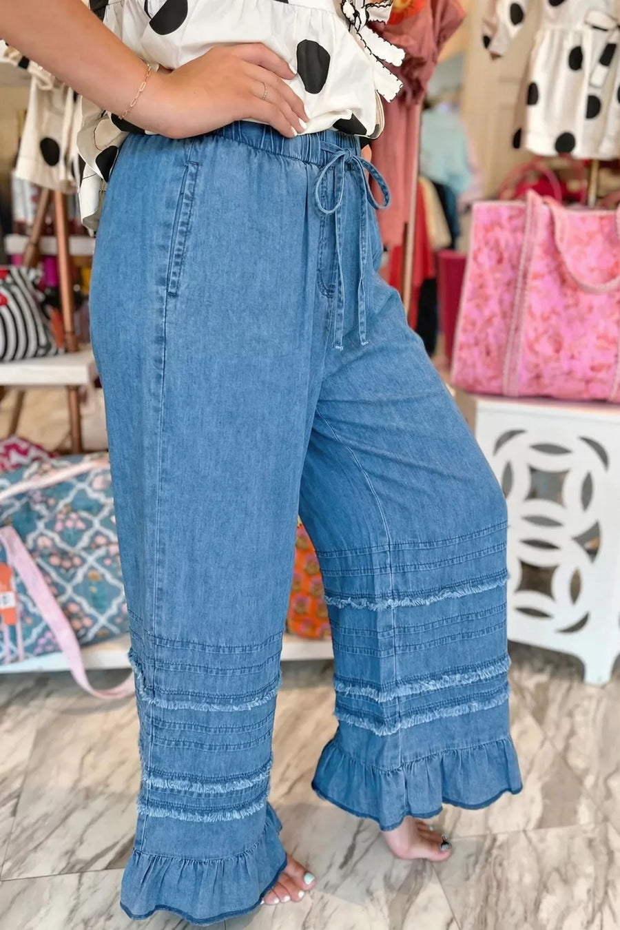Maternity wide-leg chambray jeans in blue with ruffled hem and drawstring waist.