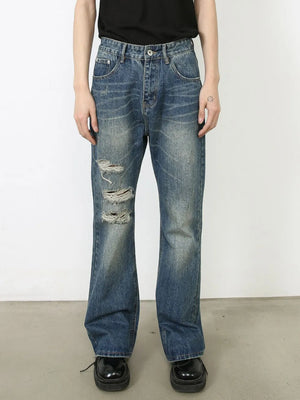 Distressed flare leg jeans in medium wash denim with ripped details.