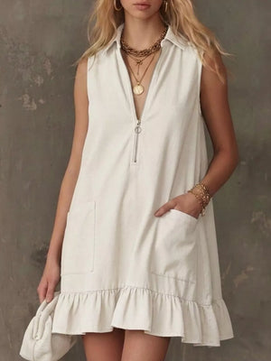 White zip-front collared sleeveless dress with ruffle hem and pockets.