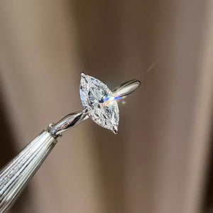 Marquise cut diamond engagement ring with a silver band.