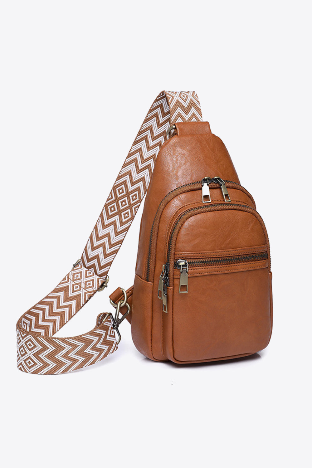 Brown leather sling bag with geometric strap and multiple zippered pockets.