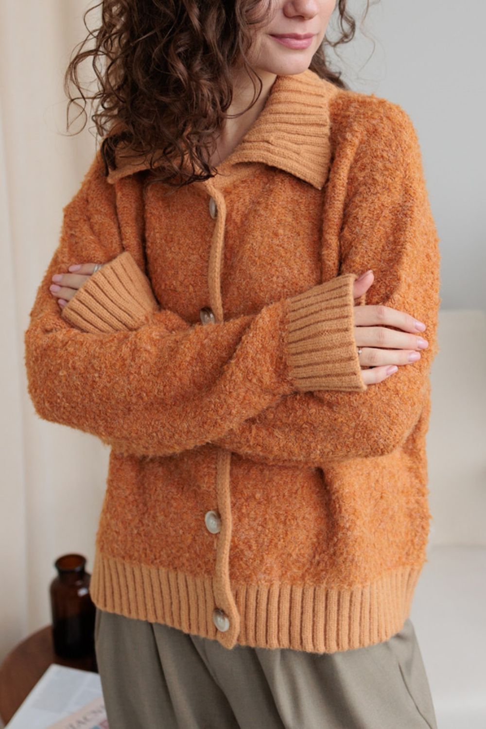Textured bouclé collar cardigan in tangerine with button front and ribbed cuffs and hem.