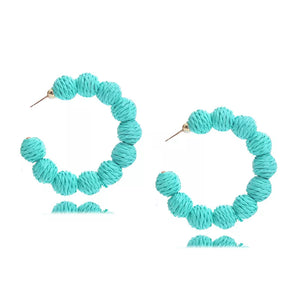 Raffia grass C-hoop earrings in blue green, featuring textured spherical beads on a gold-tone hoop.