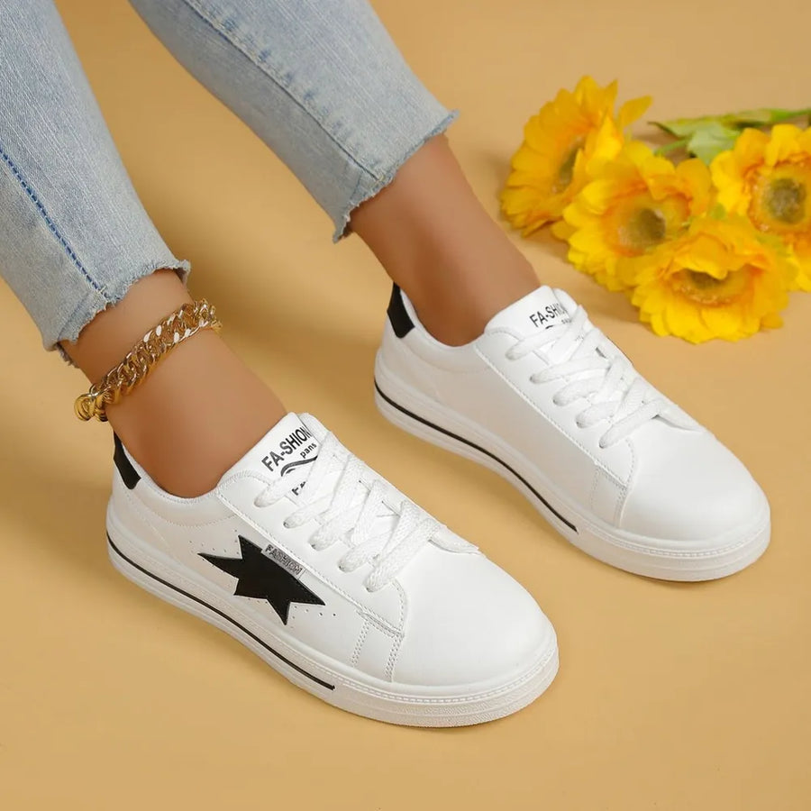 White sneakers with black star patch and black heel detail.