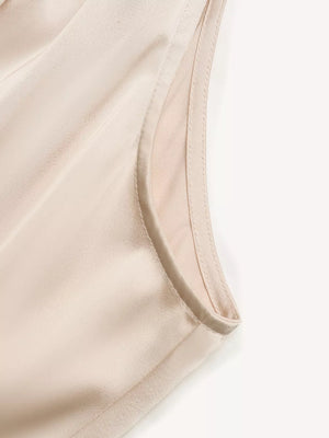 Elegant satin midi dress in champagne with pearl embellishments, showing neckline detail.