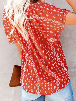 Red floral print v-neck blouse with tie detail, short sleeves, and a relaxed fit.