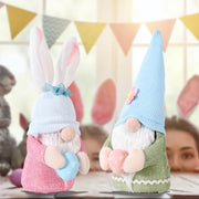 Pink and blue knit gnomes with bunny ears and Easter eggs, cute holiday decor.