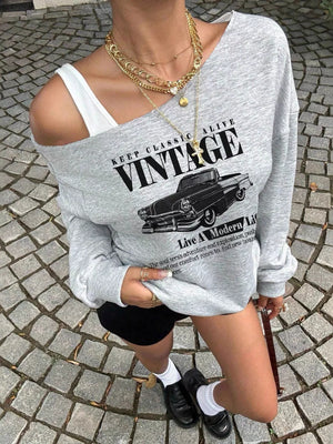 Grey oversized asymmetrical long-sleeve sweatshirt with vintage car graphic and text detail.