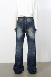 Distressed flare jeans in medium wash denim with raw edge finish and ripped details.