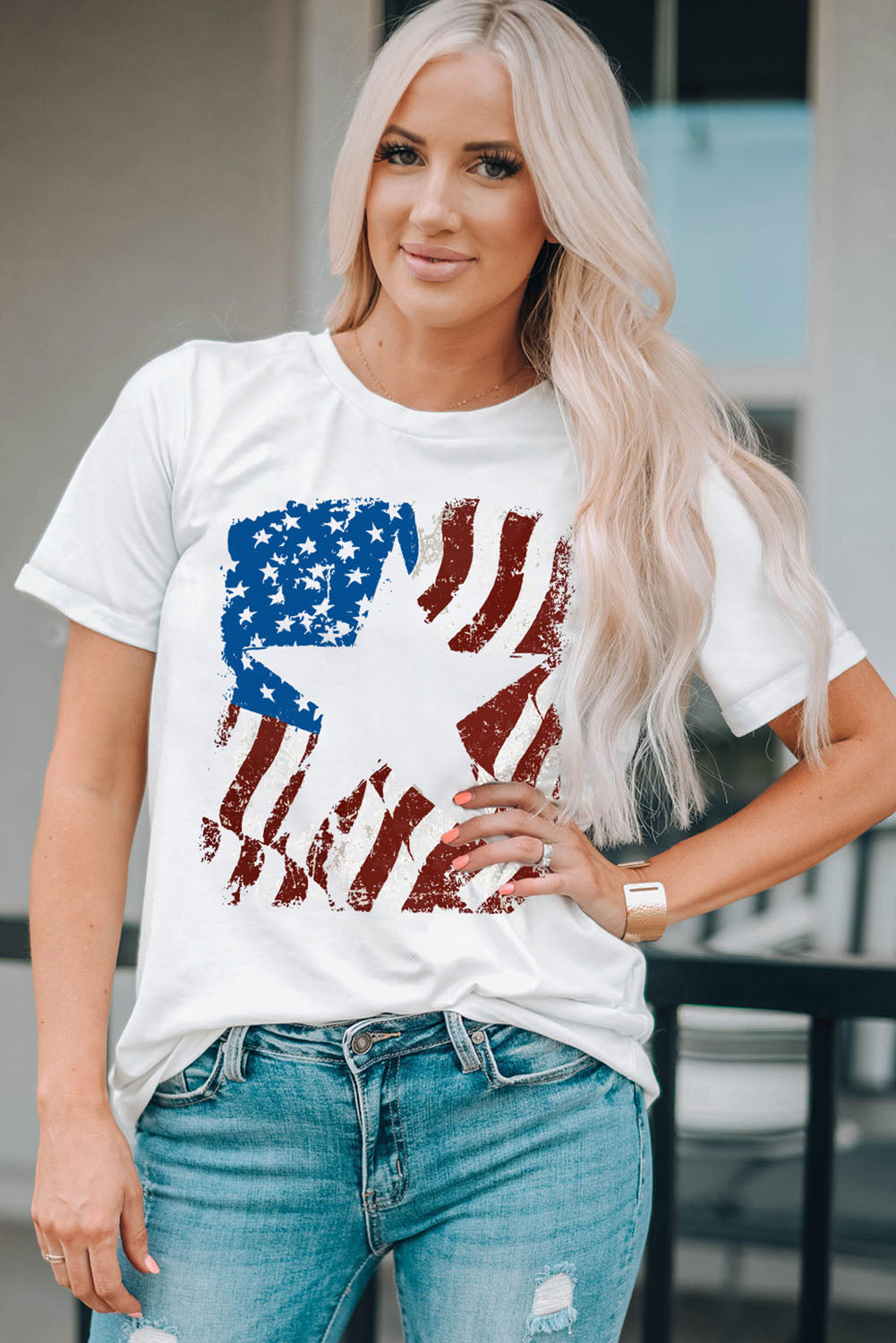 White t-shirt with distressed American flag graphic and round neck.