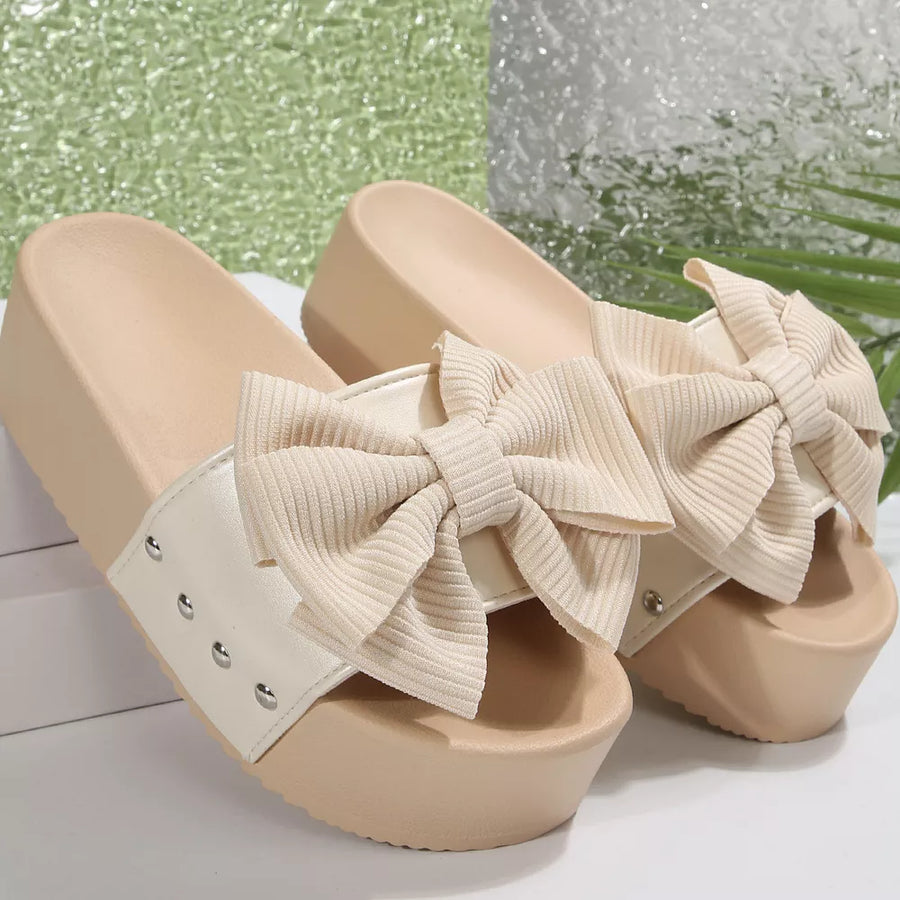Ribbed bow accent platform sandals in white with beige soles and bows.