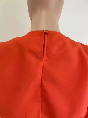 Orange crop top with button closure at the back neck