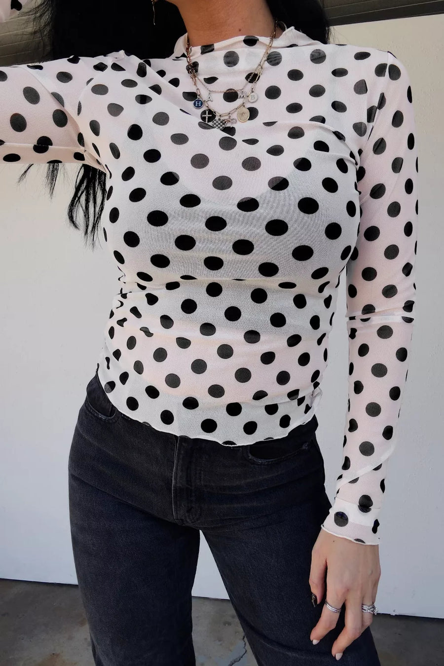 White polka dot mesh mock neck shirt with long sleeves.