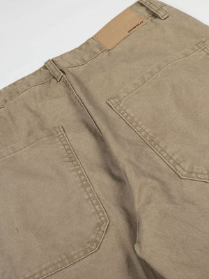 Khaki cargo pants with distressed details and a leather patch.