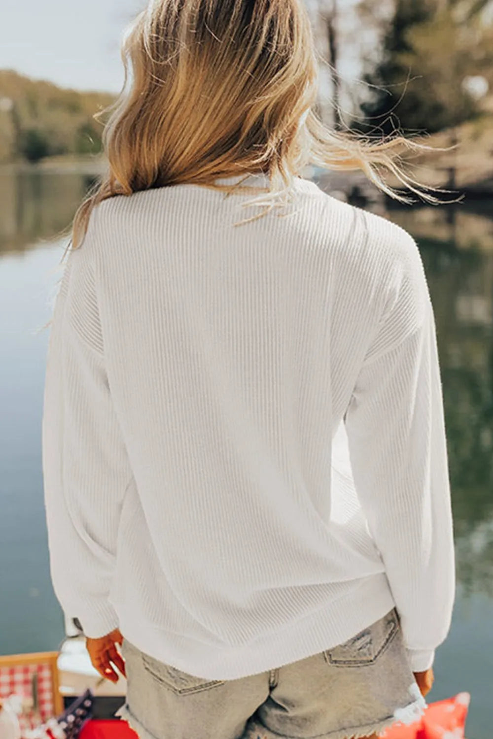 White ribbed knit sweatshirt with long sleeves, casual fit, and crew neck.