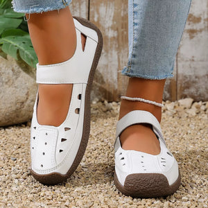 White leather round toe platform flats with cutouts and adjustable strap.