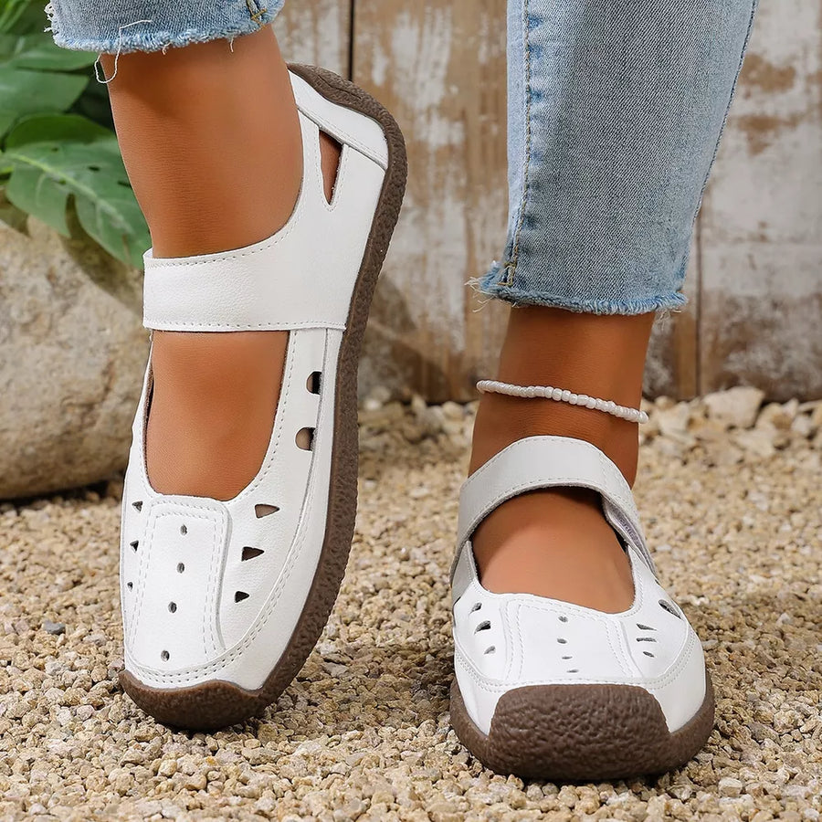 White leather round toe platform flats with cutouts and adjustable strap.