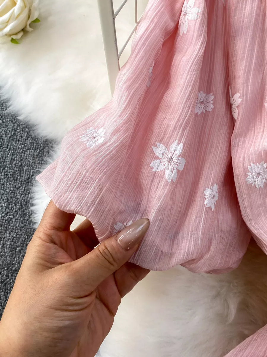 Dusty pink midi dress with white floral embroidery and puff sleeves.