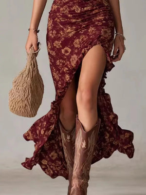 Burgundy floral ruched maxi dress with ruffled high slit and flowing hem.