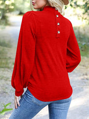 Red puff sleeve mock neck top with button back detail.