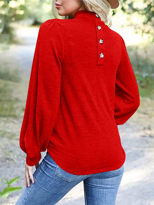 Red puff sleeve mock neck top with button back detail.