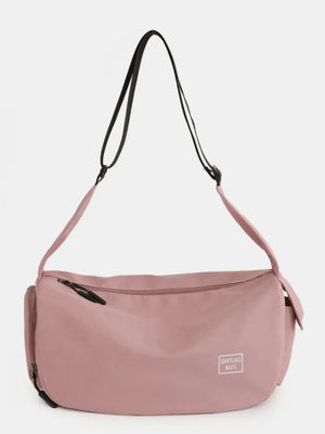 Dusty pink slouchy crescent crossbody bag with adjustable strap and zipper closure.