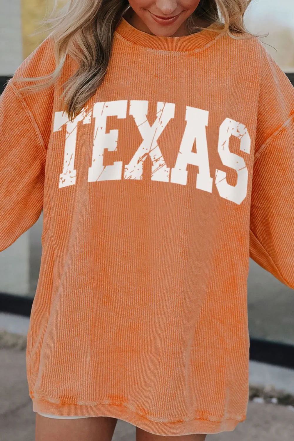 Textured sherbet crewneck sweatshirt with white distressed TEXAS graphic.
