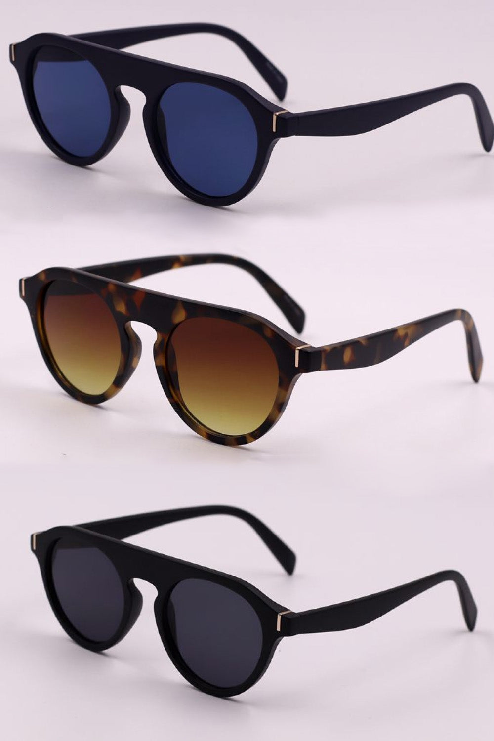 Round frame sunglasses in royal blue, gradient brown, and dusty blue with black frames.