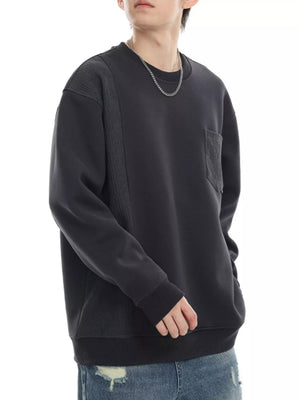 Dark gray sweatshirt with crew neck, textured paneling, and chest pocket.