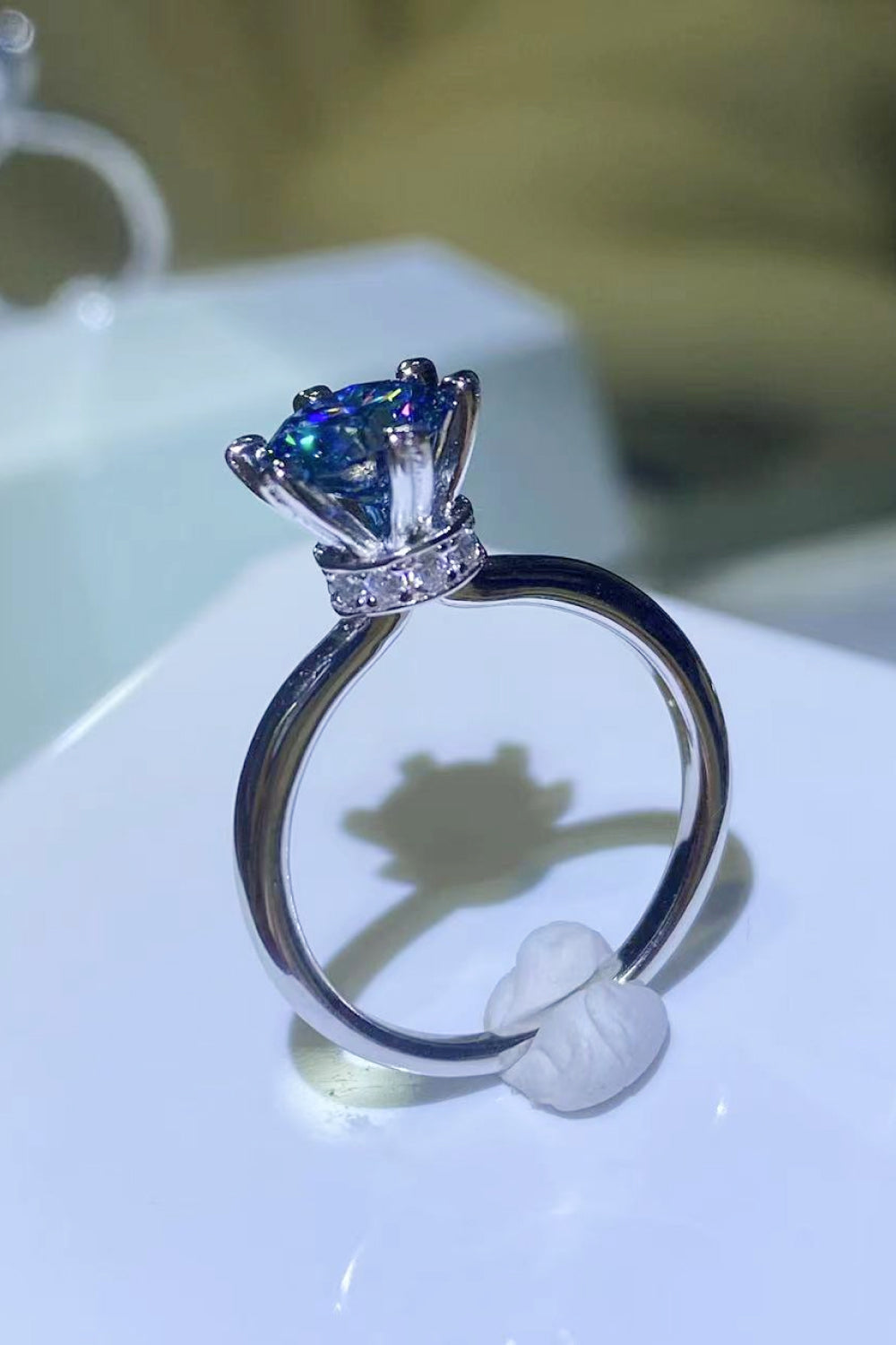Blue moissanite ring with six-prong setting and diamond band