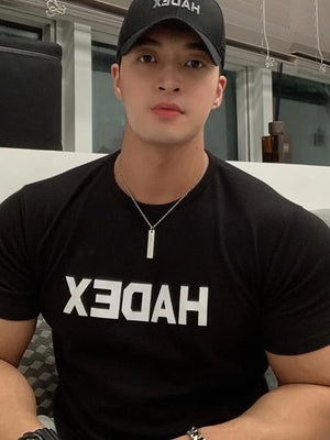Black crewneck t-shirt with reversed white graphic text and short sleeves.
