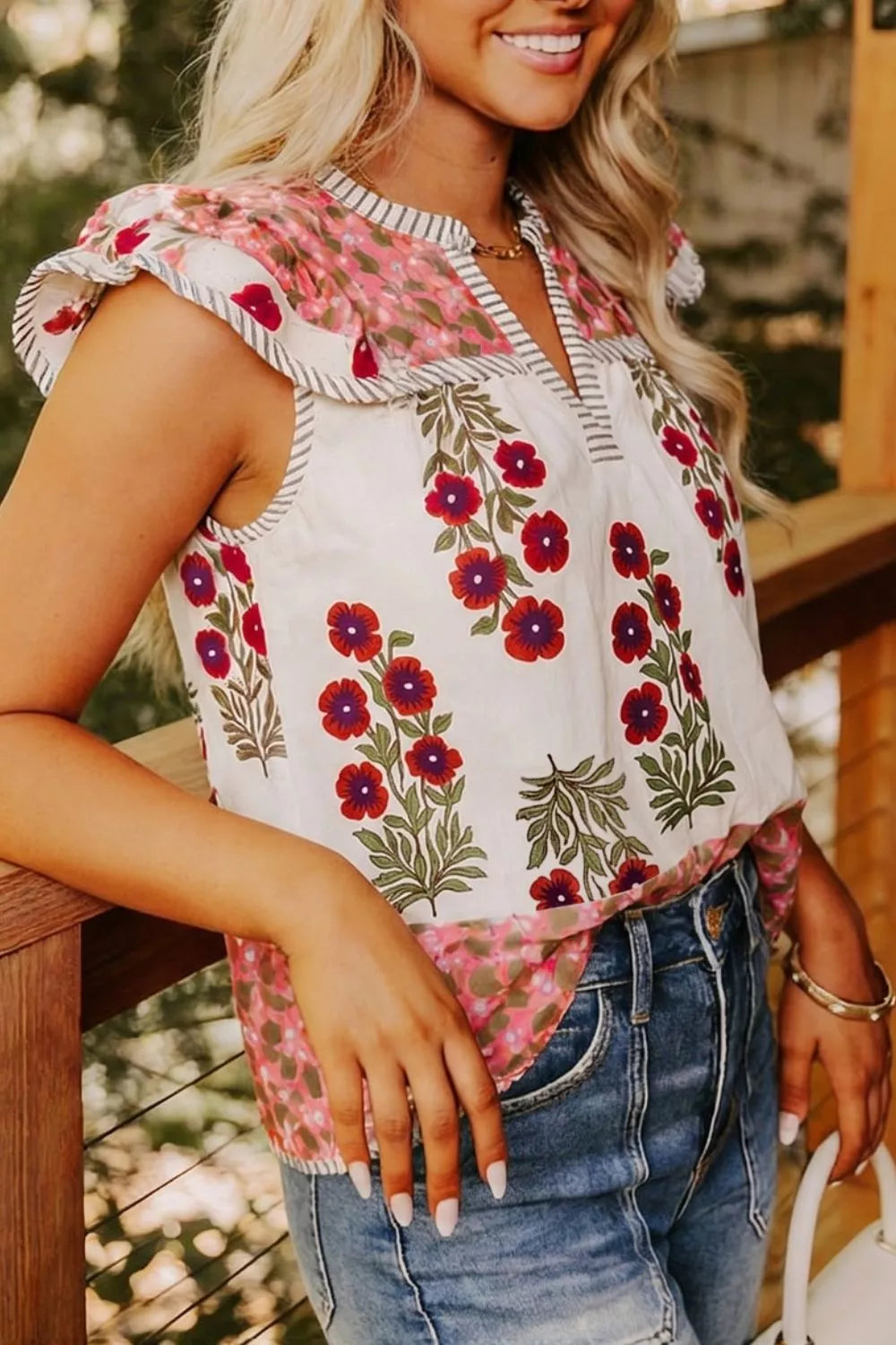 Vibrant floral cotton blouse with ruffled sleeves and striped trim