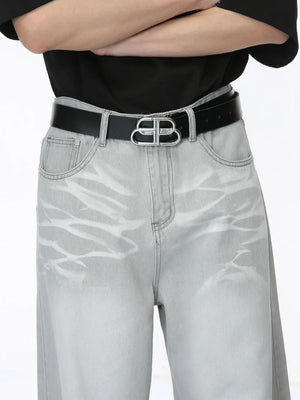 Light wash straight leg denim jeans with whiskering detail and a silver logo belt.