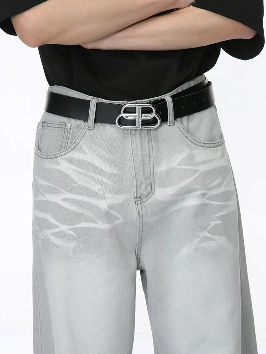 Light wash straight leg denim jeans with whiskering detail and a silver logo belt.