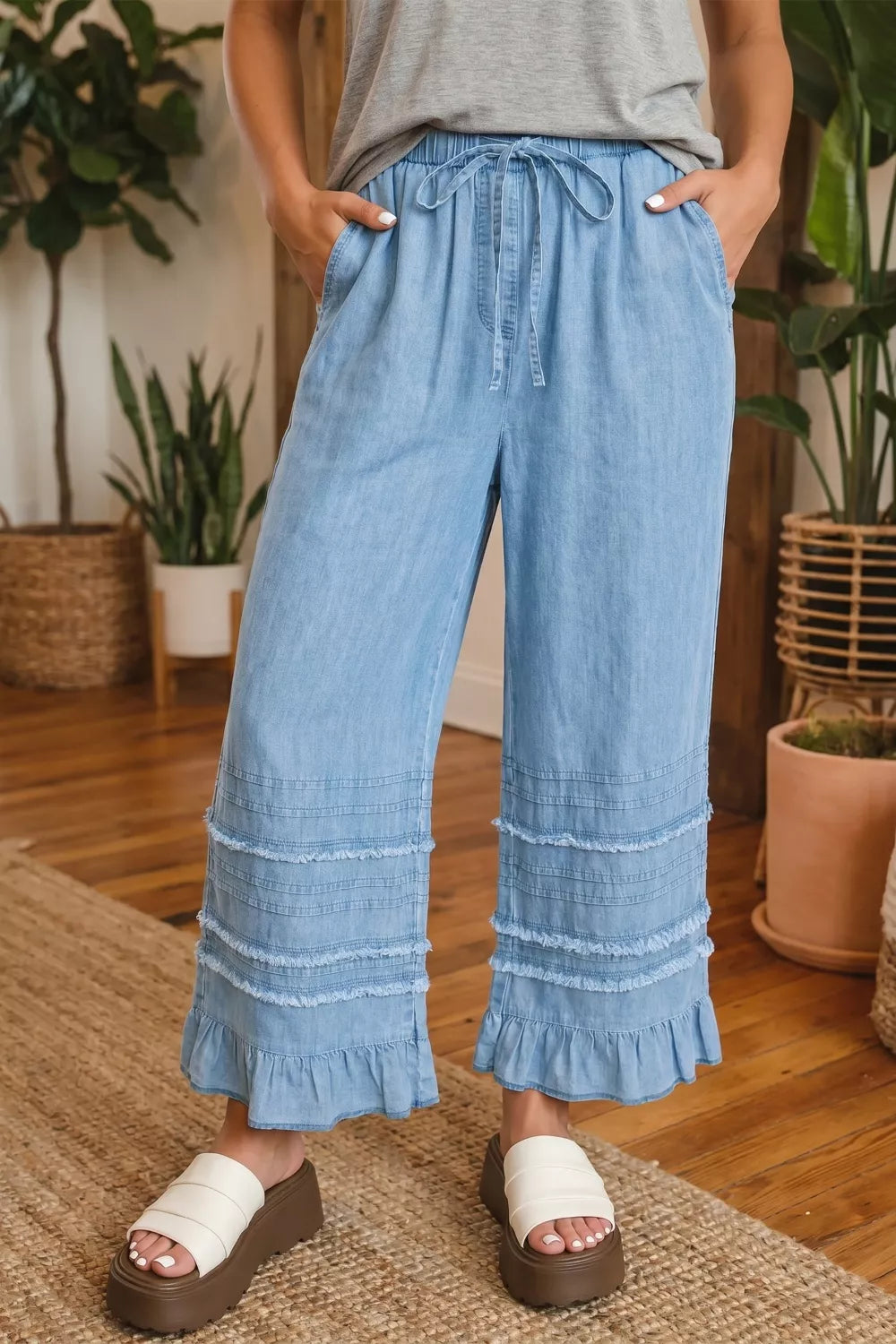 Light blue denim wide-leg cropped pants with tiered ruffled hem and drawstring waist