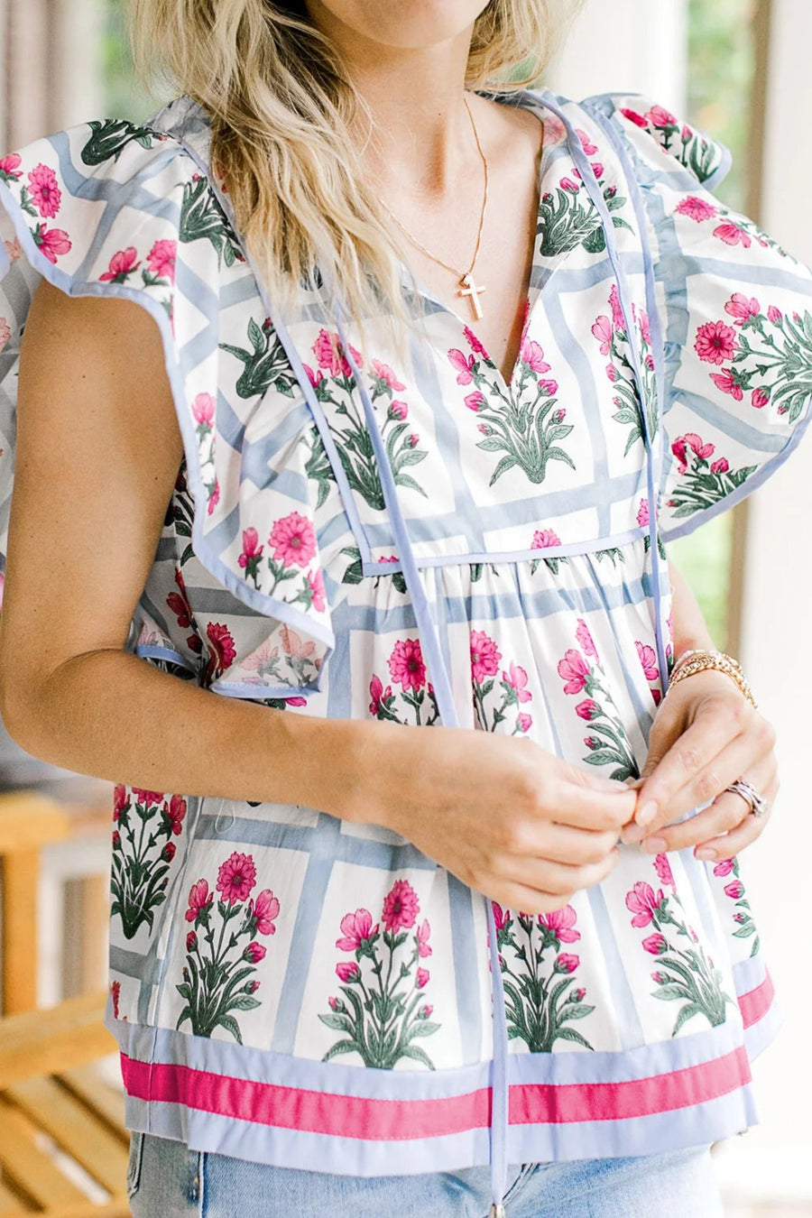 Women's ruffle sleeve blouse with floral print, blue stripes, and tie neck